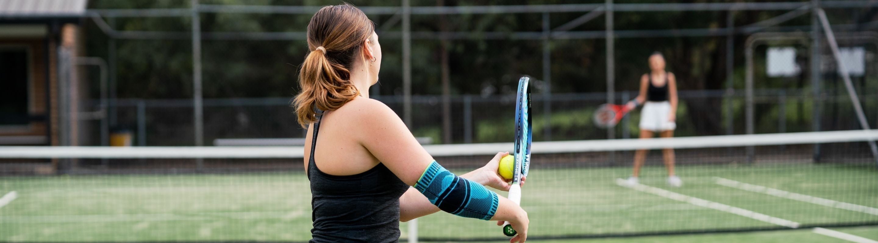 woman playing tennis. She is wearing Bauerfeind's Sports Elbow Support. It has moisture wicking knit for comfort