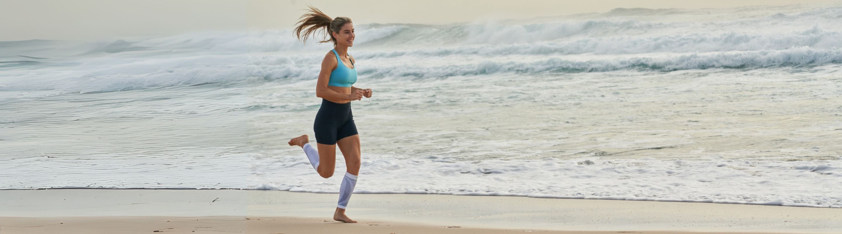 woman running on the beach. She is wearing Bauerfeind's Sports Compression Calf Sleeves
