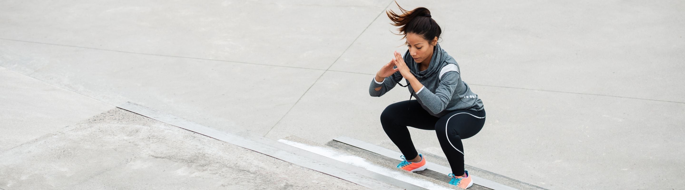 Woman doing jump squats on a stairwell to strengthen her inner thighs and avoid imbalance