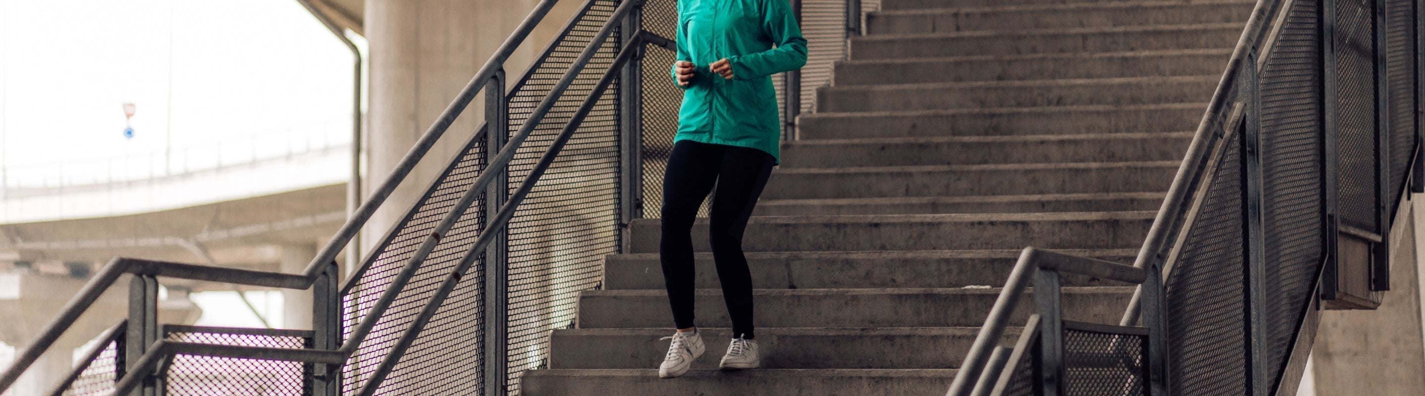woman doing step-downs on a stairwell