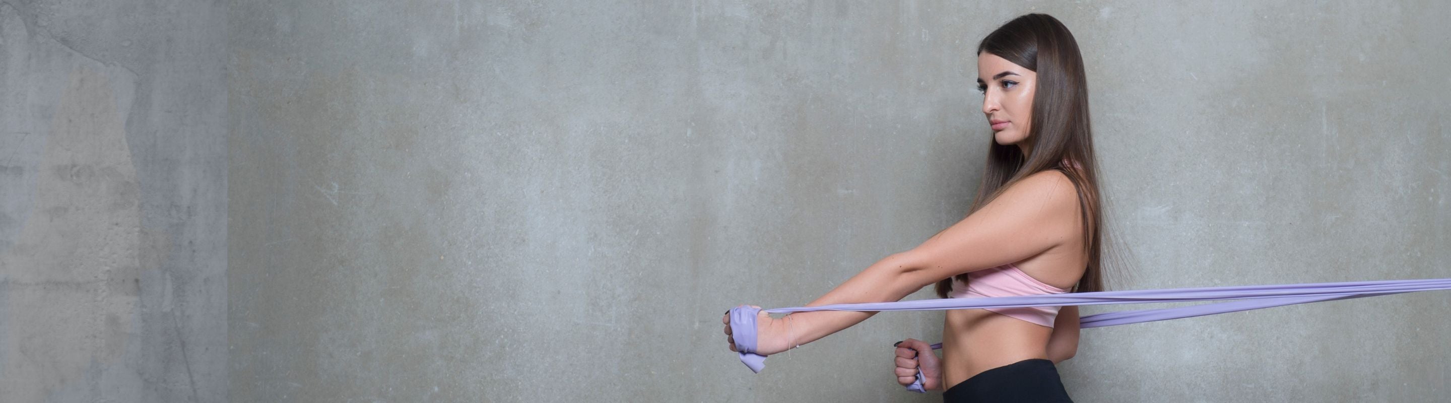 woman doing shoulder rotations with resistance band