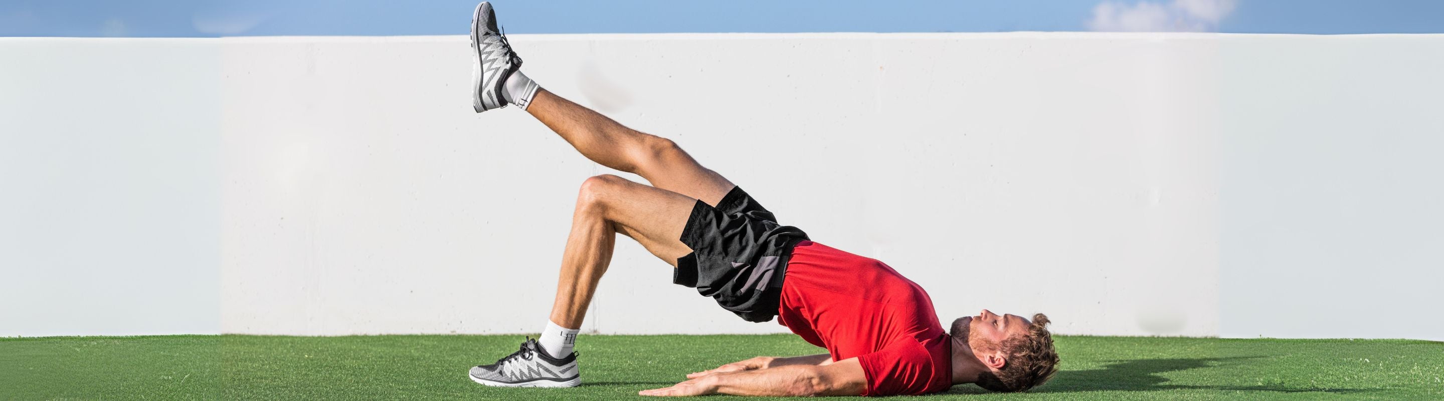 Man doing the glute bridge with leg extension