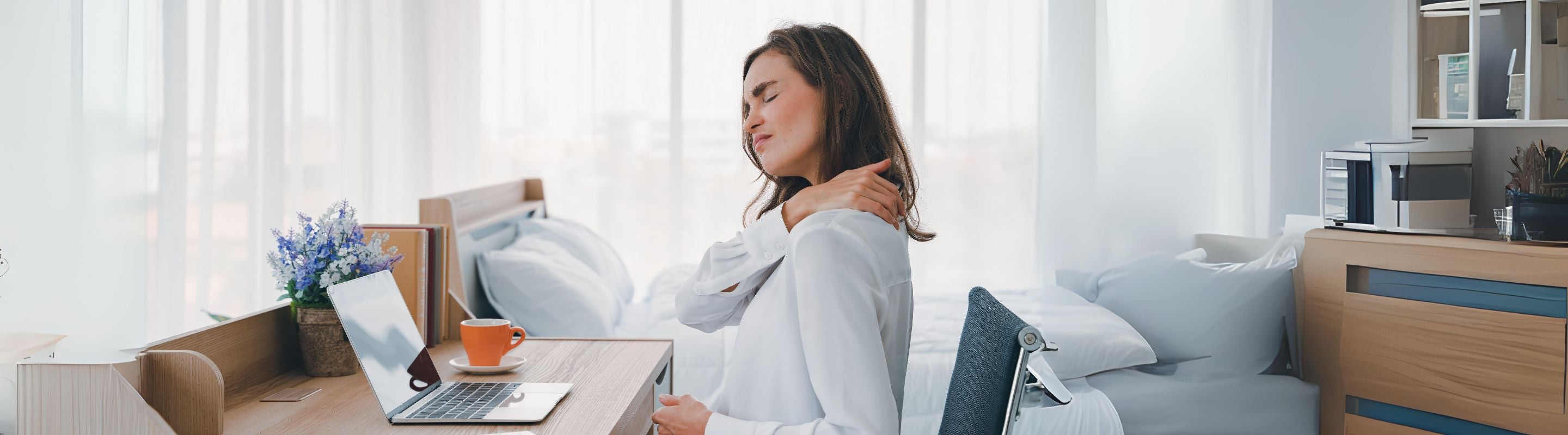 Back pain after sitting all day. Girl sits at a desk, working on a laptop