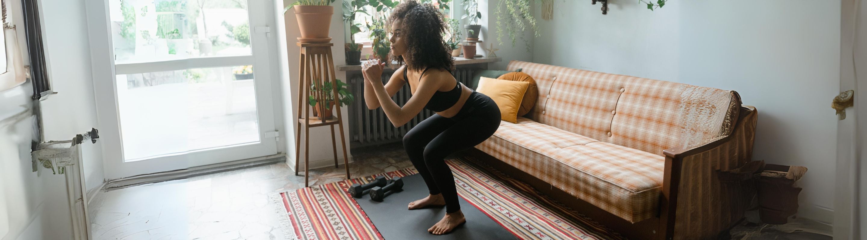 Woman performing the sit to stand exercise in her living room to improve her core strength