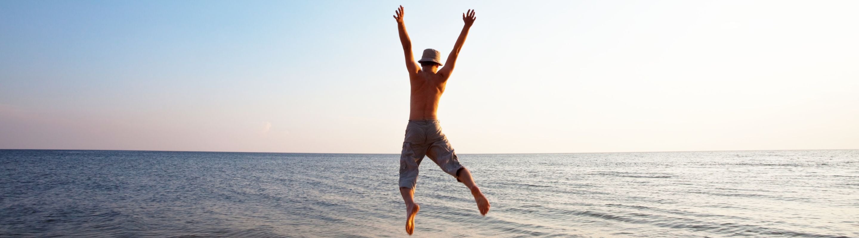 man doing jumping jacks at the beach