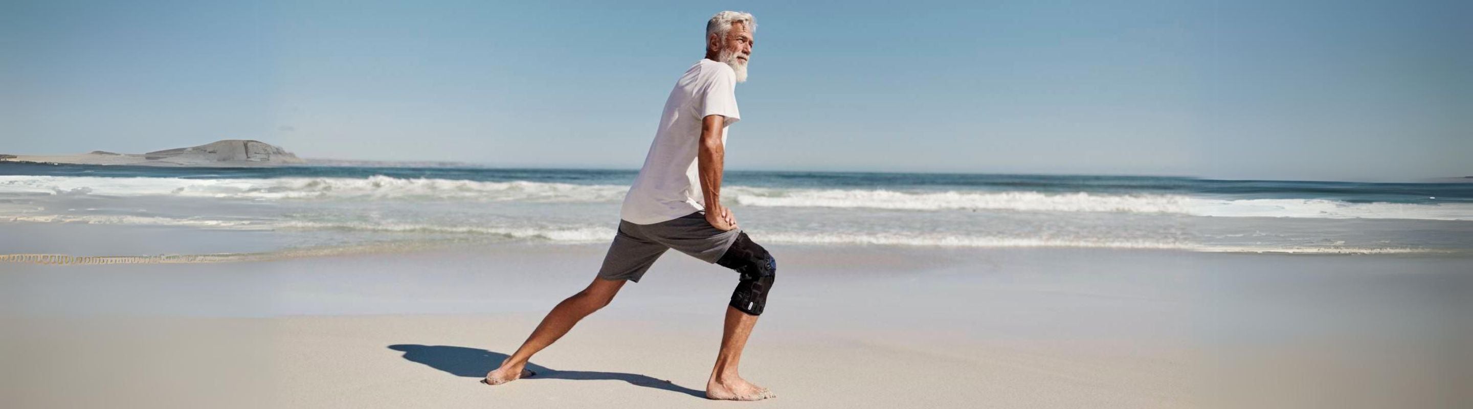 Man doing lunges at the beach in Bauerfeind's GenuTrain OA Knee Brace as part of knee arthritis treatment without surgery