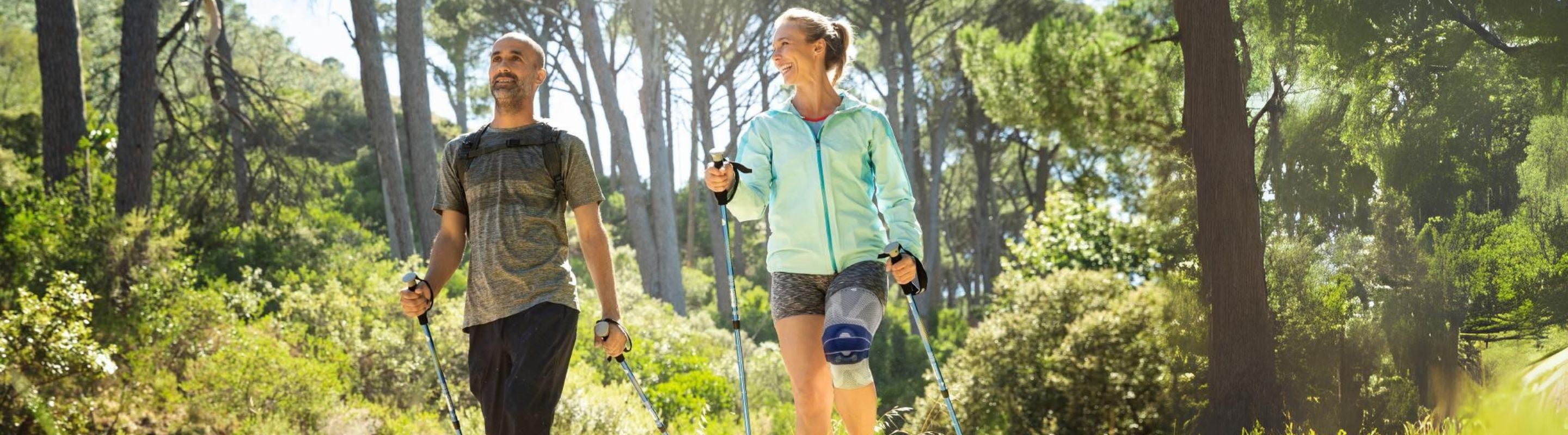 Woman with knee brace/support is running along on side-walk near the ocean