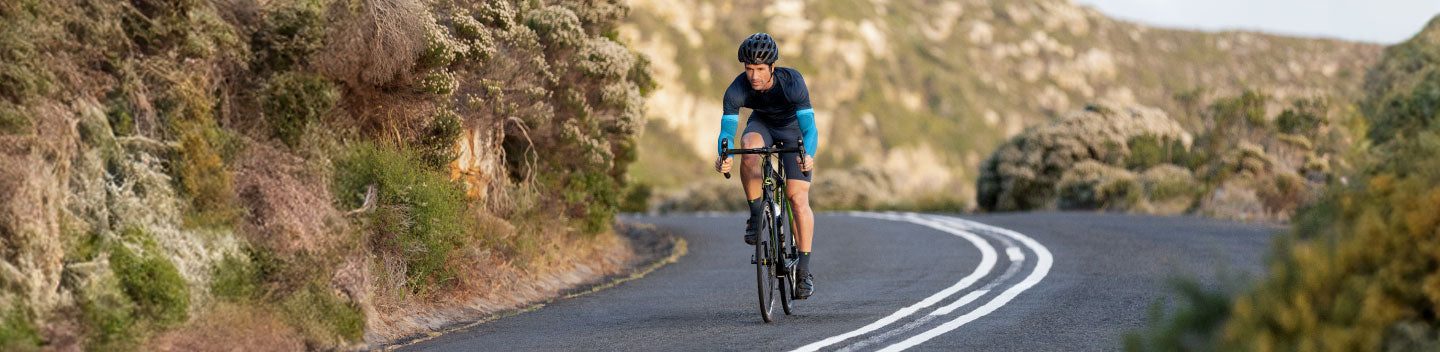 Man cycling in a triathlon. He is wearing Bauerfeind's Compression Arm Sleeves to reduce fatigue and boost circulation