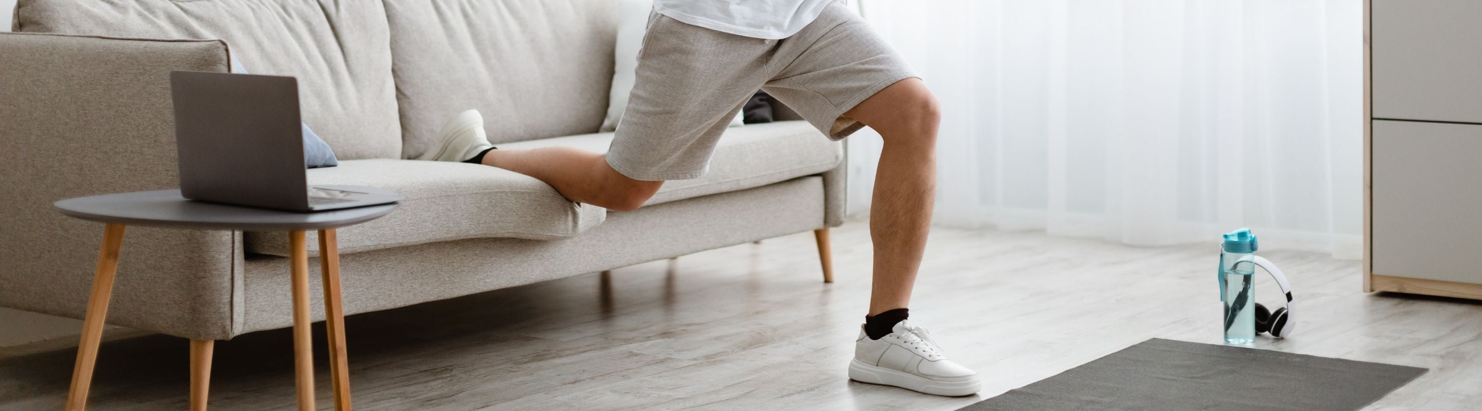 Man performing split squats at home using his couch 