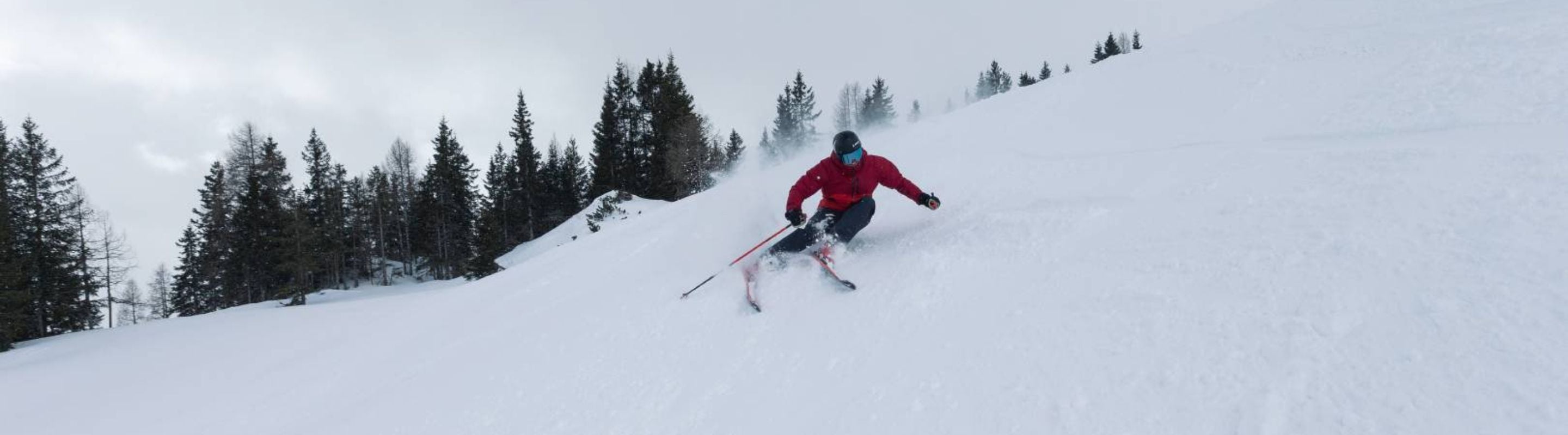 Skiing beginner skiing down a snowy mountain, nearly falling to their side