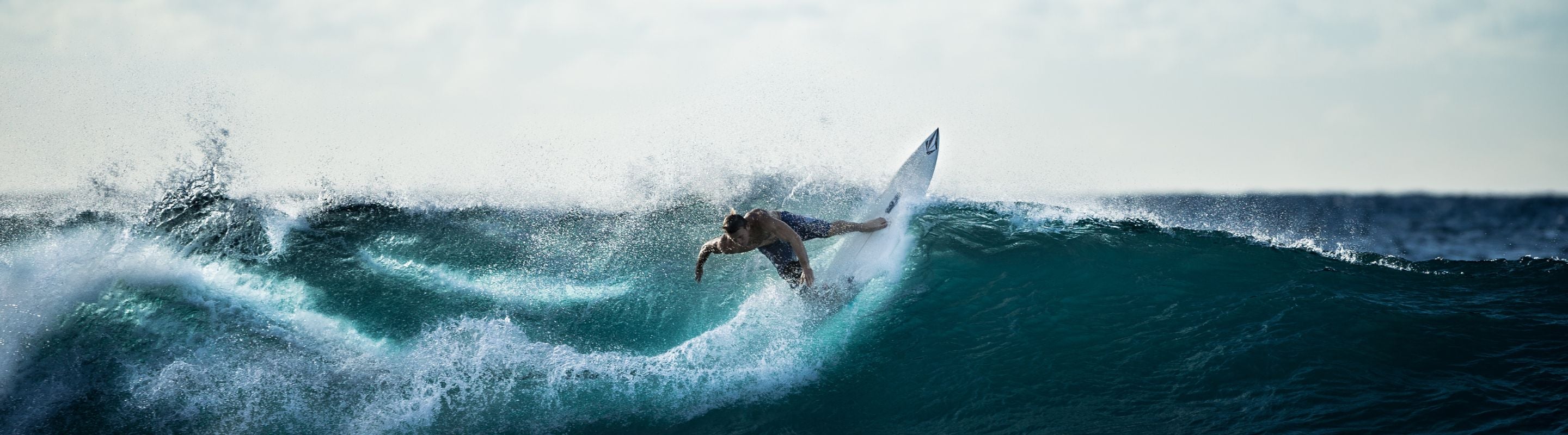 Person in a wetsuit surfing, keeping their balance on the waves