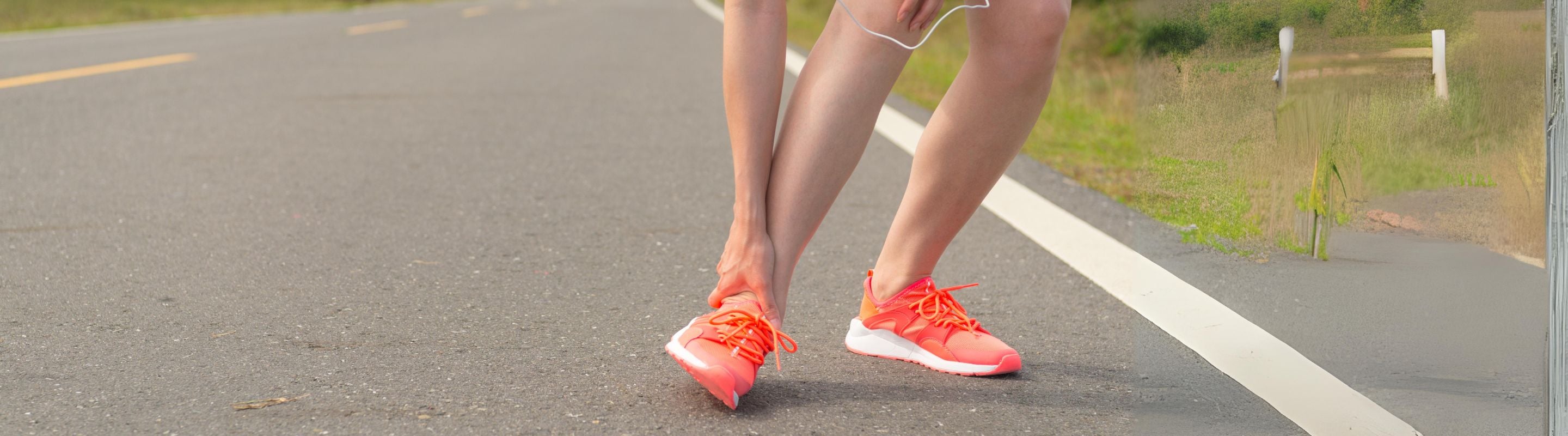 Why Are My Ankles Itchy? woman scratching her ankle at the side of a road during a run