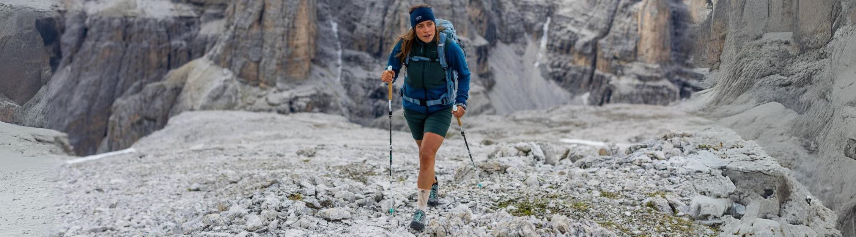 woman hiking up a mountain in winter. They're wearing Bauerfeind's Outdoor Compression Socks