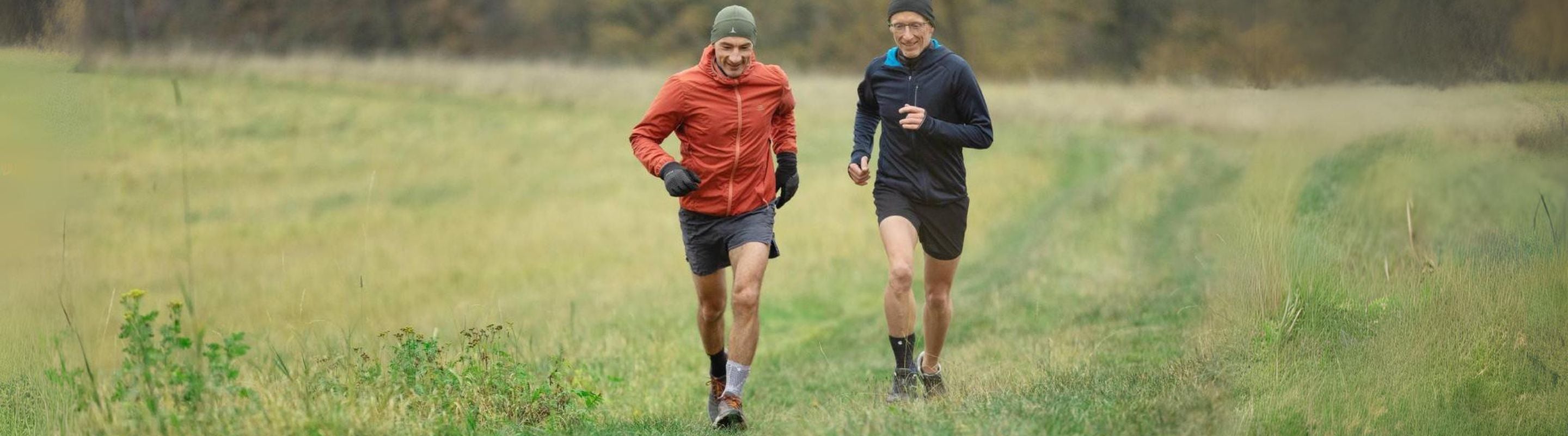 Men running through a grassy field. One is wearing an ankle brace for support after an ankle injury