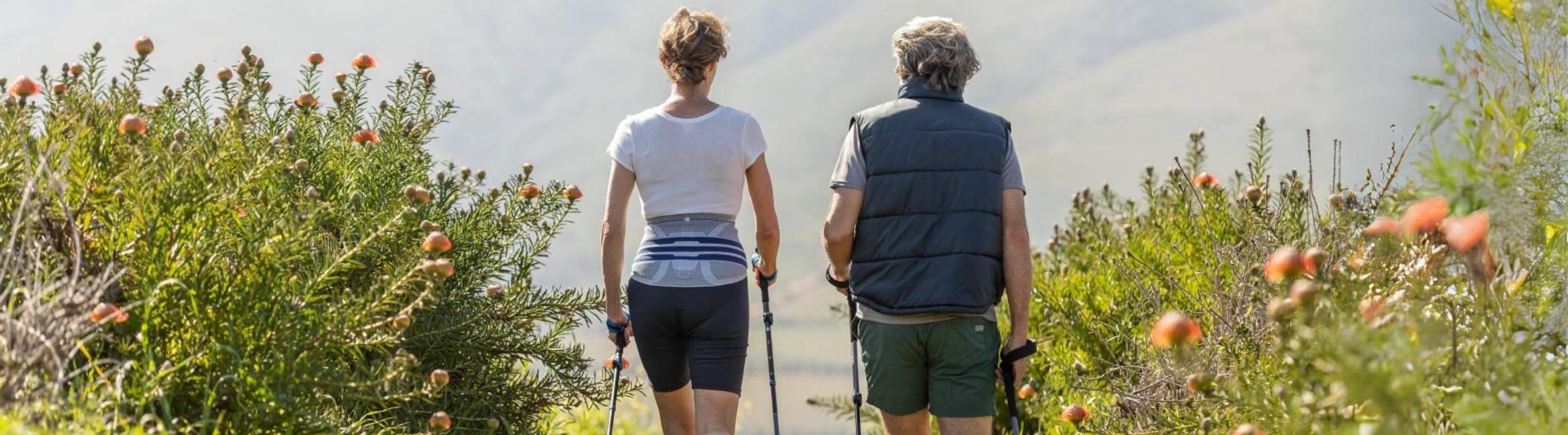 Woman and man hiking. She's wearing a LumboTrain Back Brace