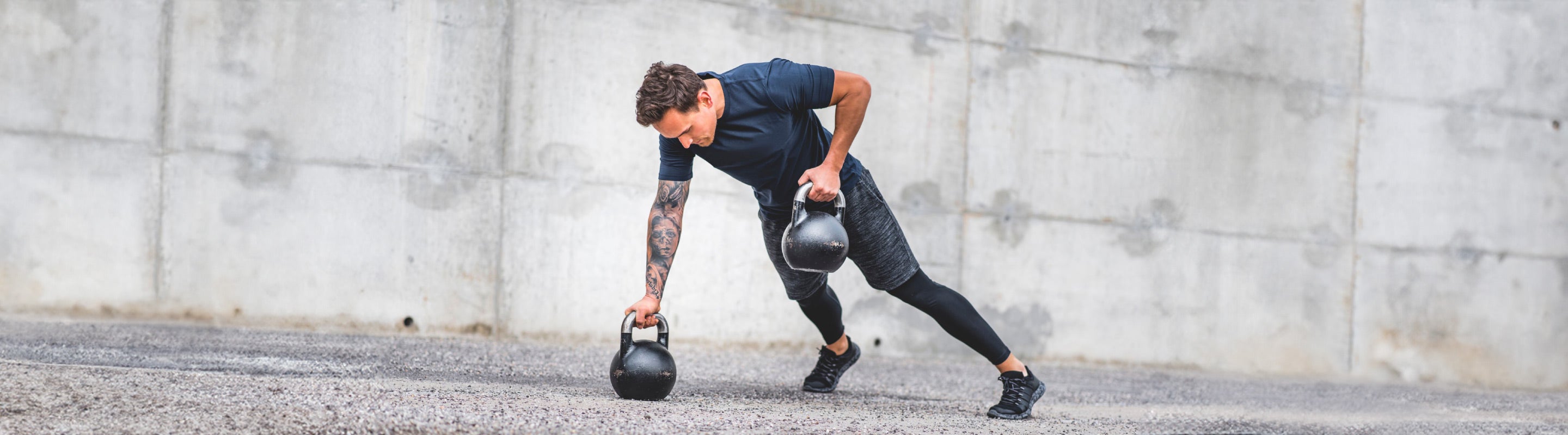 Man performing plank rows shoulder and core exercise at the beach