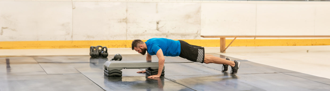 man doing the hand step-ups split exercise at the gym