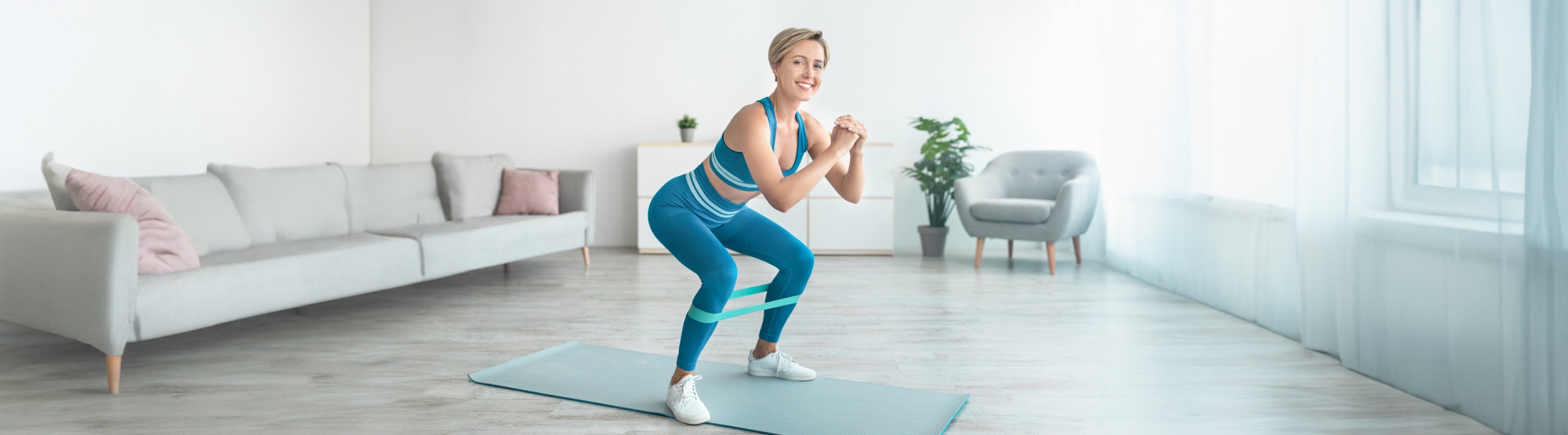 Woman performing the banded side shuffle to improve hip strength