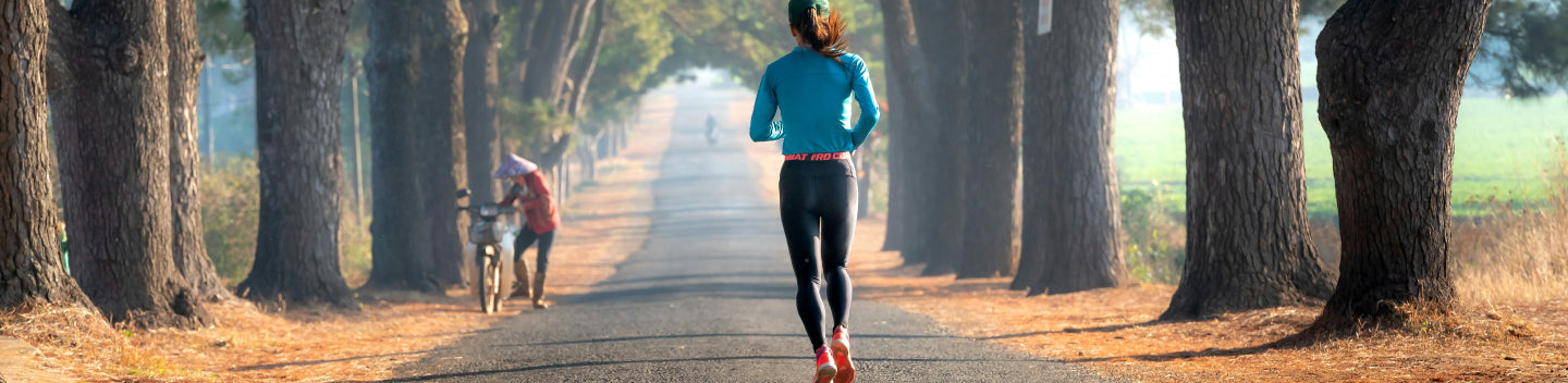 woman running on concrete path through a park