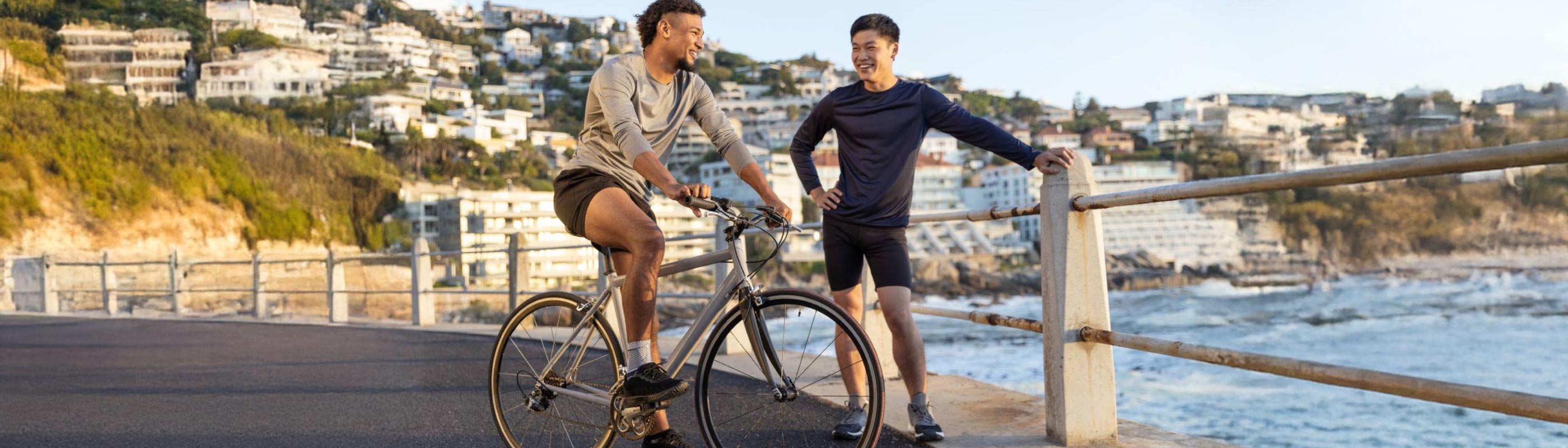 Cycling tips for beginners: man on a bike talking to his friend at bondi beach