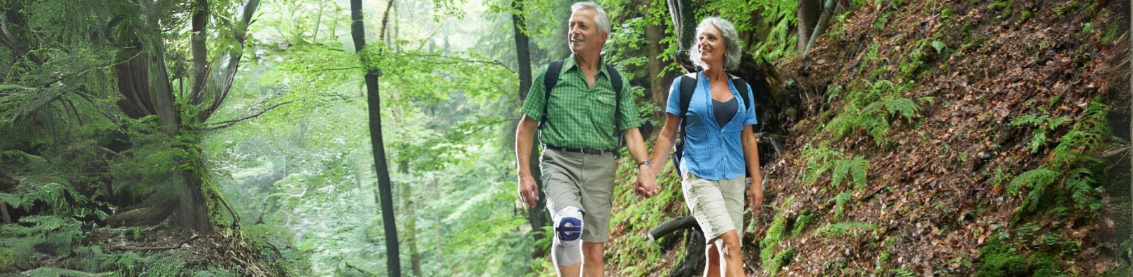 couple hiking. One is wearing a Bauerfeind knee brace to relieve arthritis paintis relief