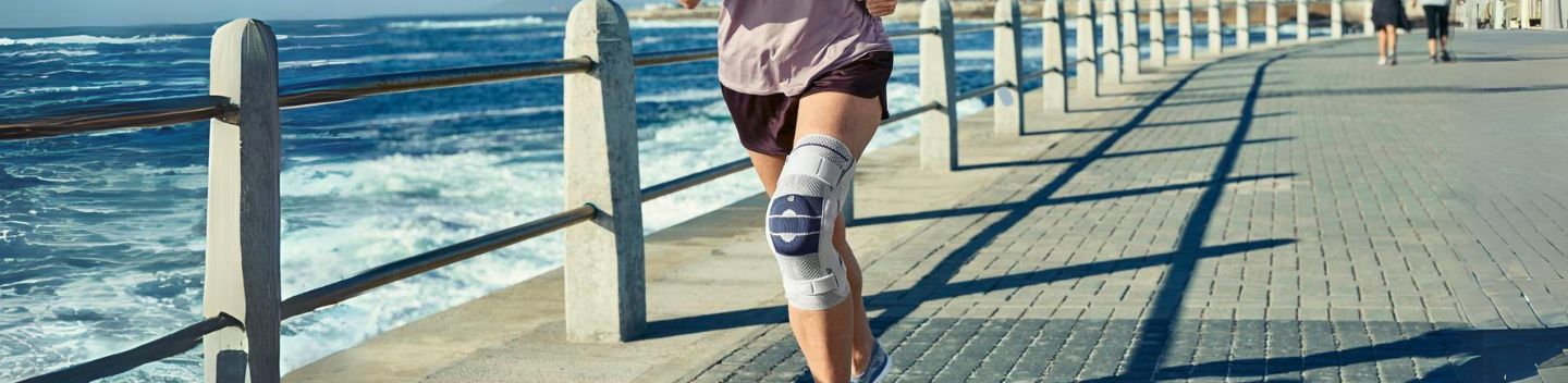 woman at the beach taking a rest while wearing the GenuTrain S Knee Brace