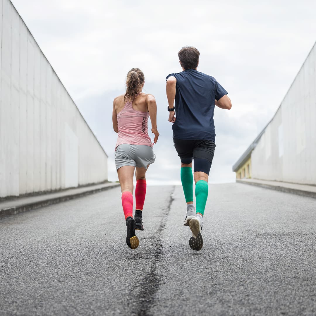 a girl and a guy running wearing Bauerfeind compression calf sleeves