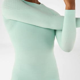 Light green Bauerfeind compression shirt worn by a person on a white background
